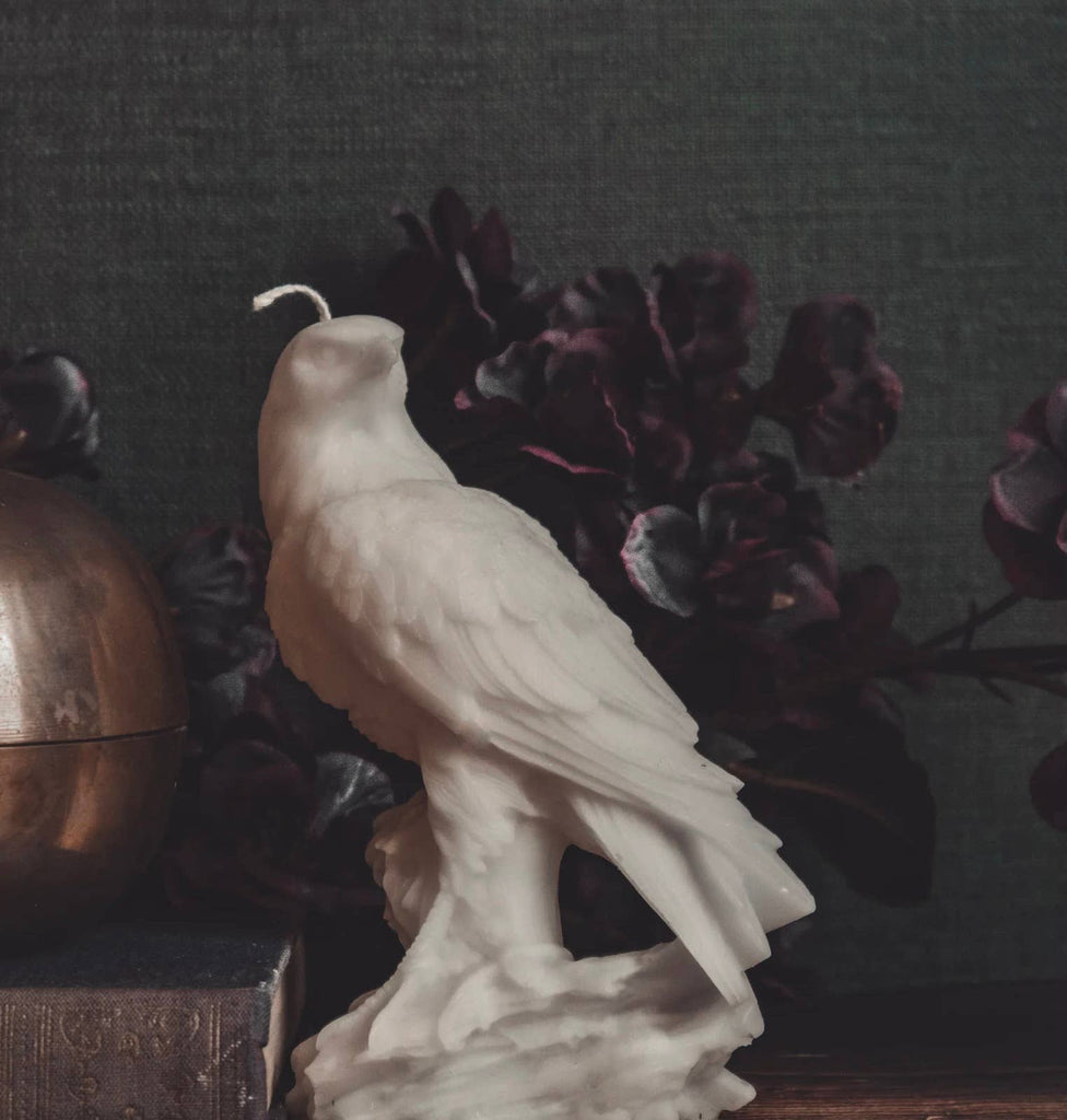 White bird candle on a dark background with decorative elements