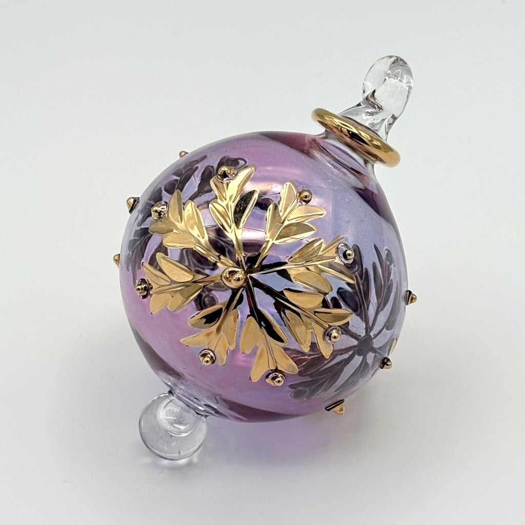 Decorative ornament with gold snowflake design on the purple glass ball