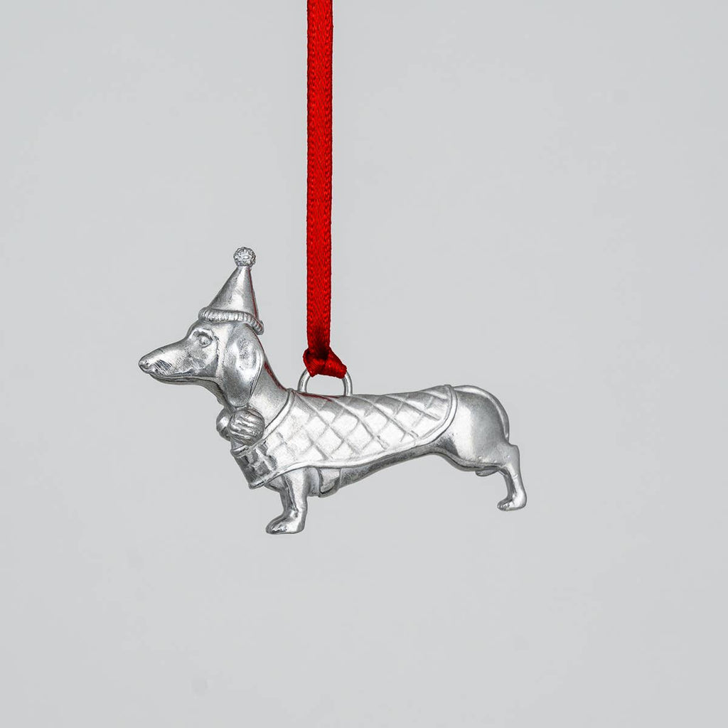 Pewter dachshund ornament with a red ribbon on a light gray background
