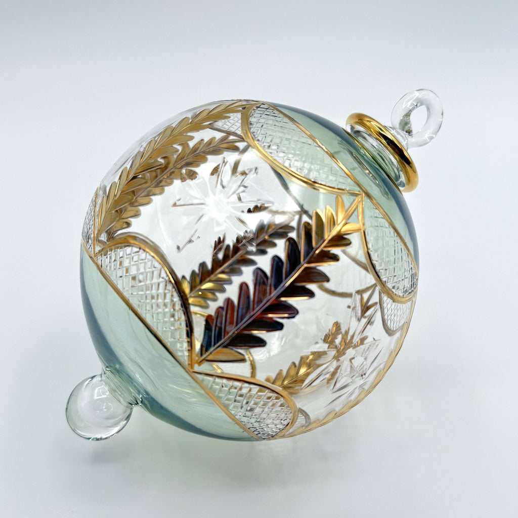 Decorative light green glass ornament with gold and silver leaf patterns 