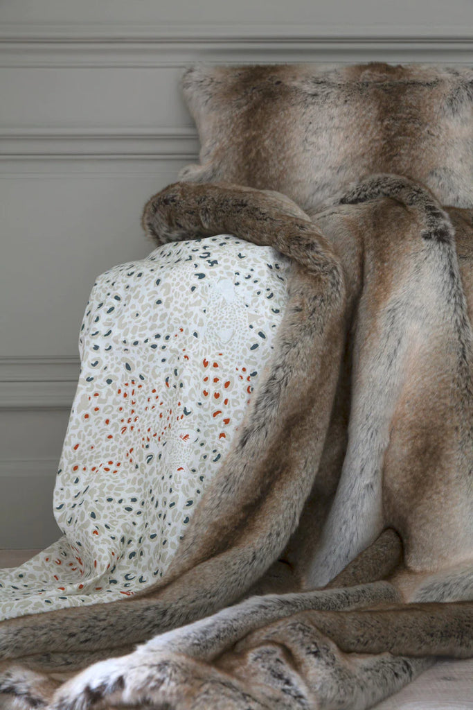 Monaco faux fur throw with Cheetah Sable print reverse draped with Monaco faux fur pillow placed on top.