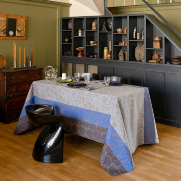 Cottage Blue tablecloth shown on table in room with chair in front and shelf unit behind