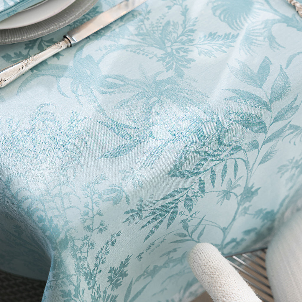 Jardin D'Eden Blue Tablecloth close up showing delicate tone on tone leaves in aqua tones.