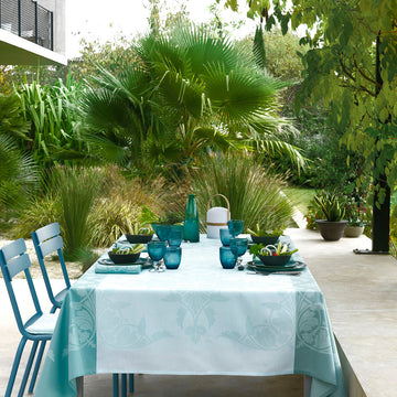Syracuse Aqua tablecloth in 3 shades of blue on table outdoors.