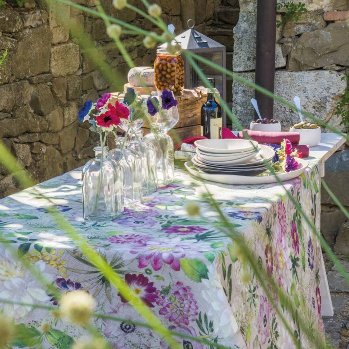 La Vie En Rose Tablecloth with printed flowers on table outdoors with flowers in vases
