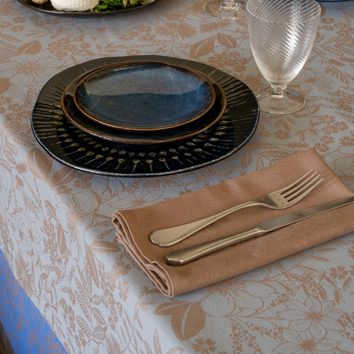 Close up of Cottage Blue tablecloth with table setting on it
