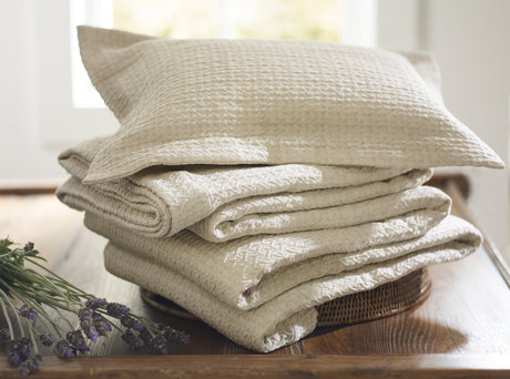 Purist Kimi Coverlet and shams on top of a basket 