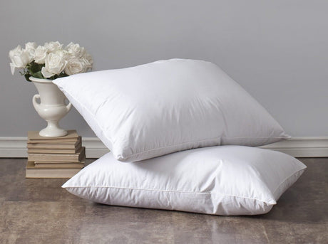 Lajord pillows stacked with vase of flowers in background