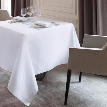 Galuchat tablecloth on a square table with wine glasses and dinner ware